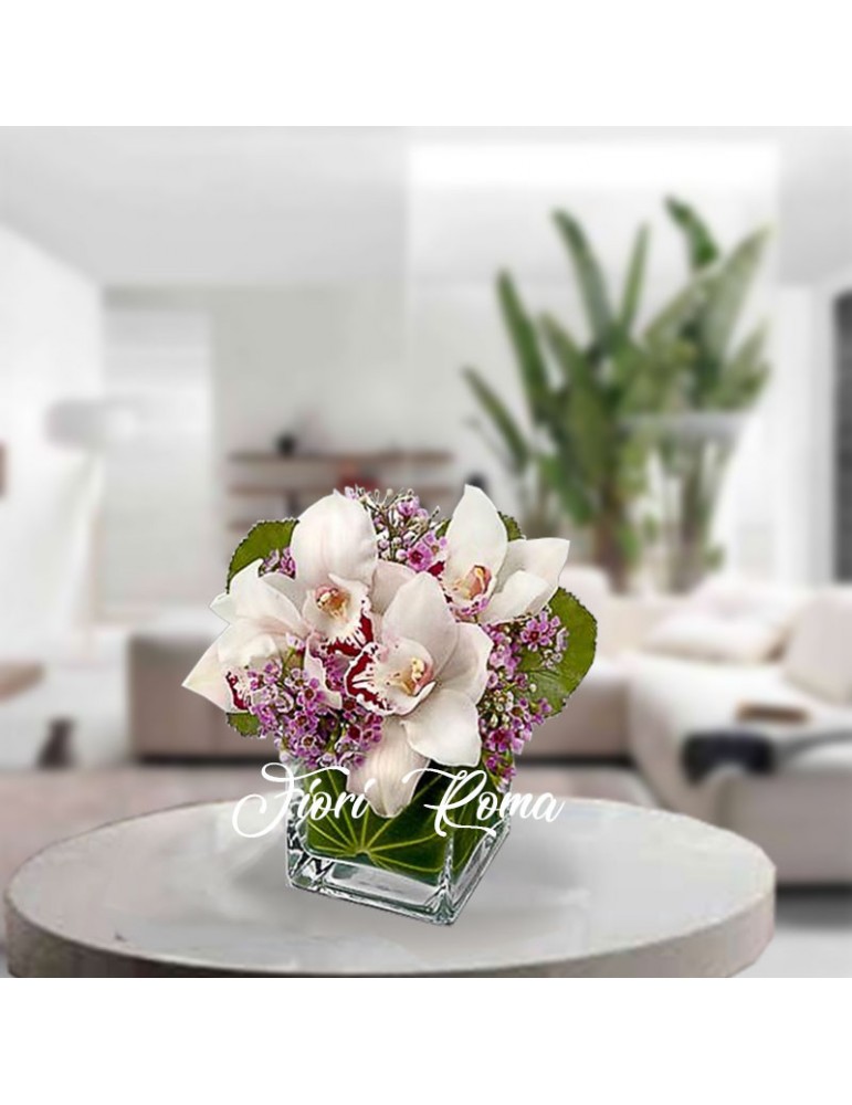 Composizione in vaso di vetro con fiori di cymbidium bianche e rosa