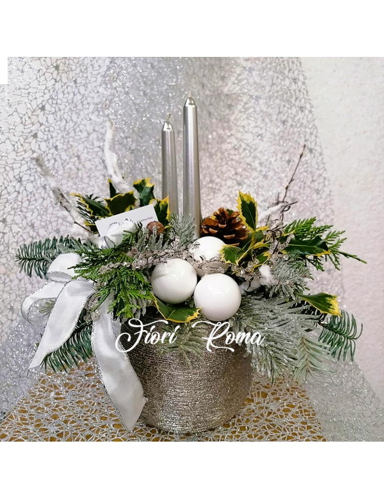 Centerpiece in silver colored ceramic vase decorated with natural green, silver candles and Christmas decorations