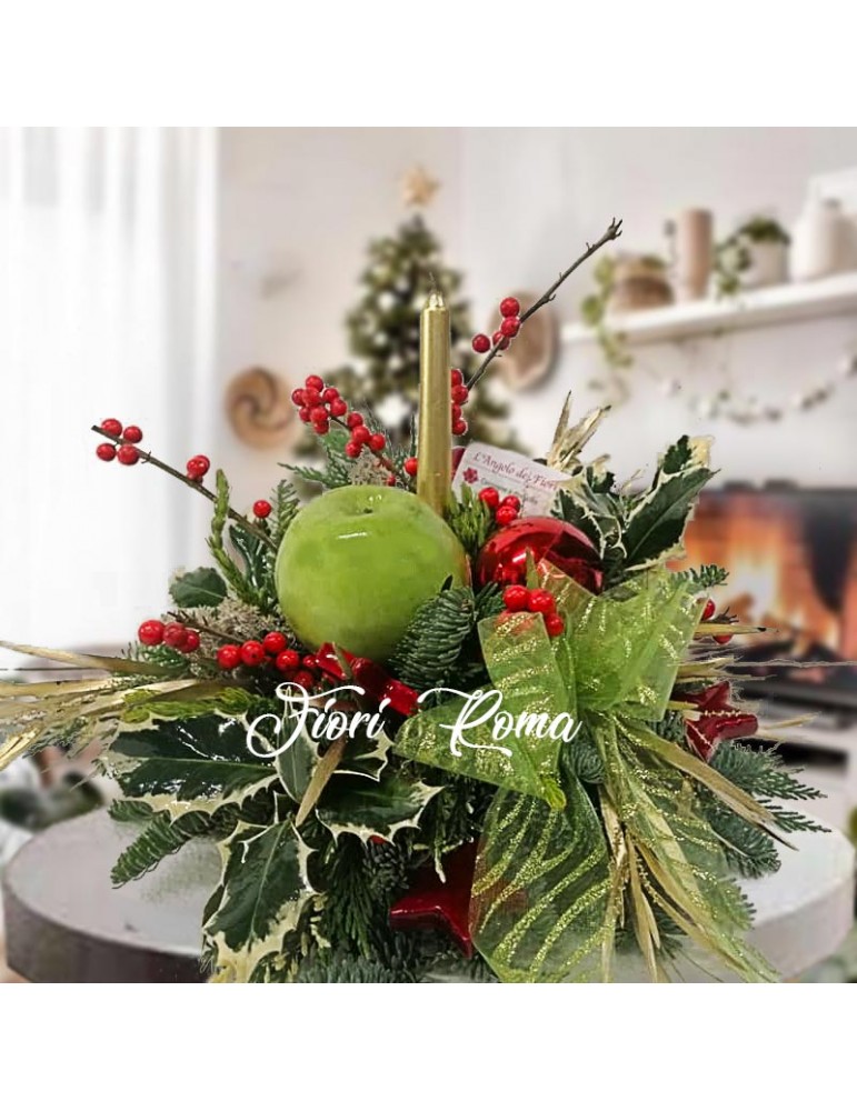 Centrotavola di colore verde con elementi naturali. Candela oro, abete,bacche di ilex mela verde fiocchi e decori natalizi.
